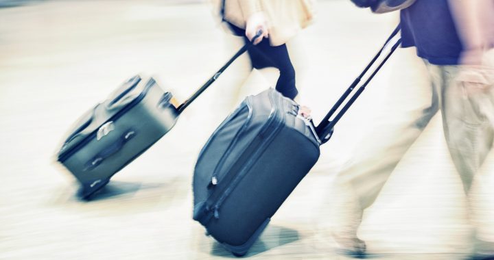 Couple walking with suitcases having asked can you take a razor in hand luggage?