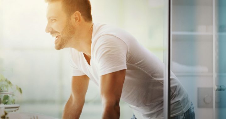 Man looking in to bathroom mirror considering a new razor